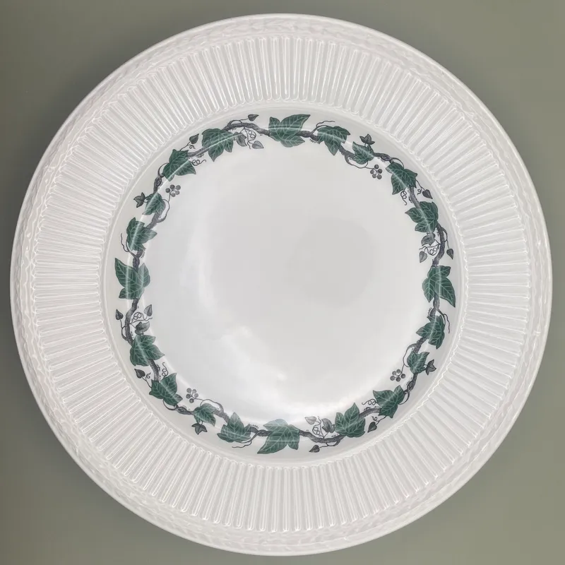 Wedgwood Stratford dinner plate 26.5cm 1 Top view of a round Wedgwood Stratford dinner plate with green ivy decor on cream pottery.